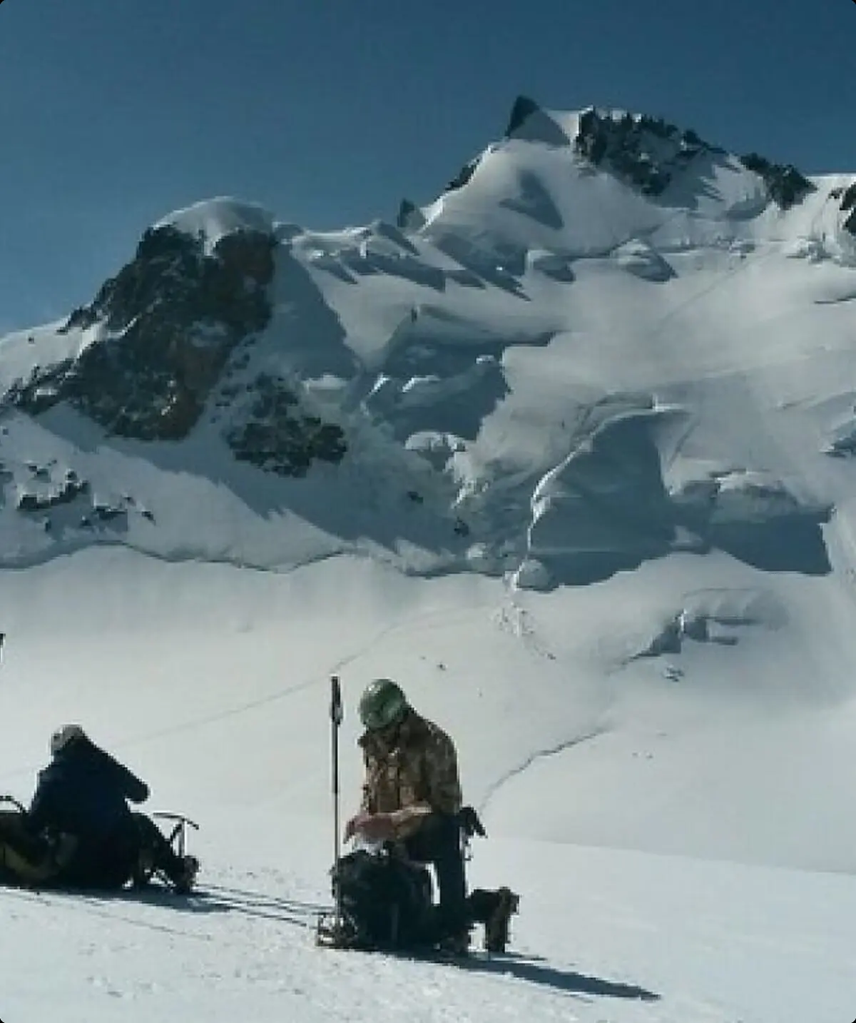Kurze Pause im Schnee vor einem schneebedeckten Gipfel | © DAV Münster