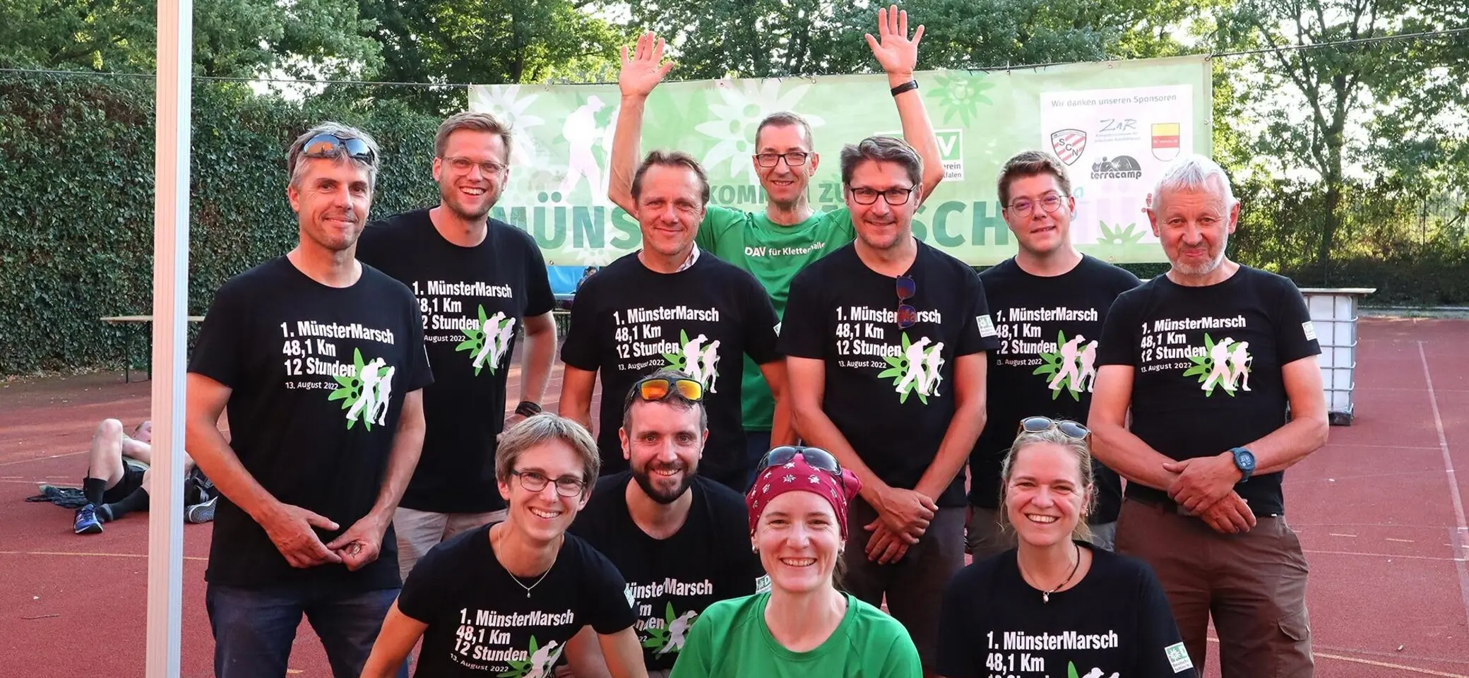 Die Orga-Team Mitglieder des MünsterMarschs sind auf einem Tennisplatz zu sehen | © DAV Münster