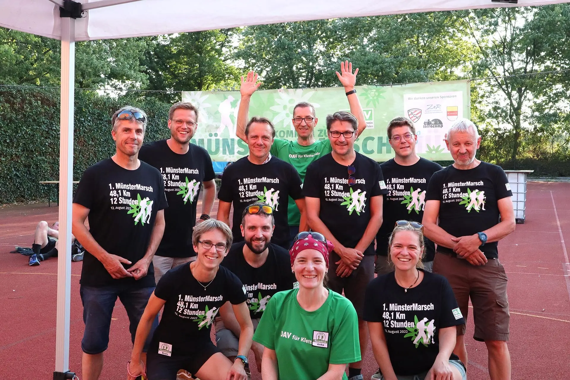 Die Orga-Team Mitglieder des MünsterMarschs sind auf einem Tennisplatz zu sehen | © DAV Münster