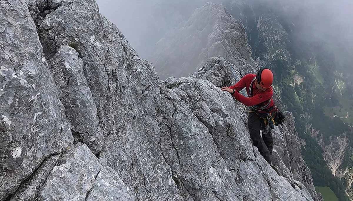 Ein Bergsteiger hangelt sich an einem Grat lang | © DAV Münster