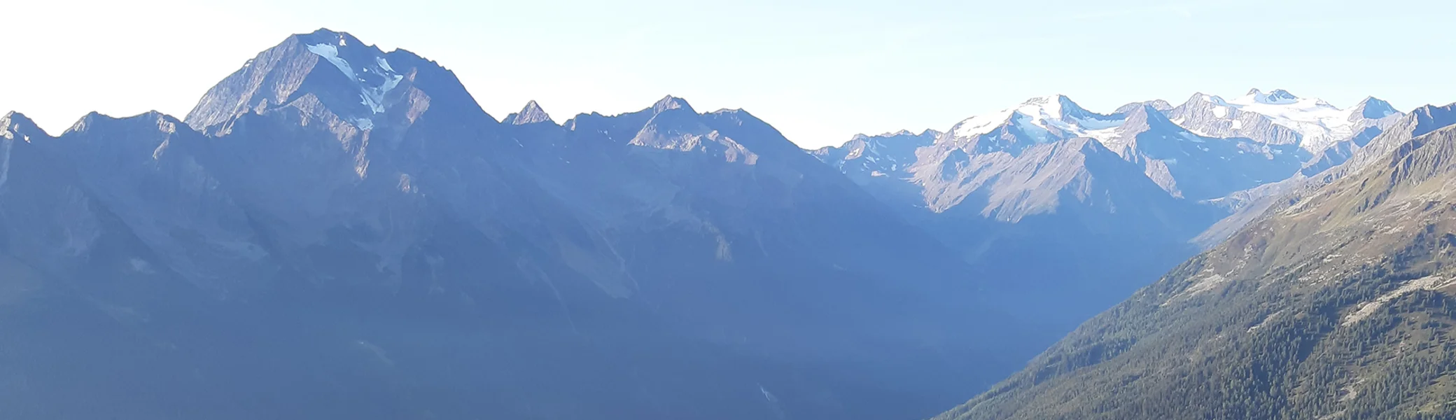 Hütten in den Bergen auf einer grünen Wiesen, im Hintergrund hohe Berge | © DAV Münster