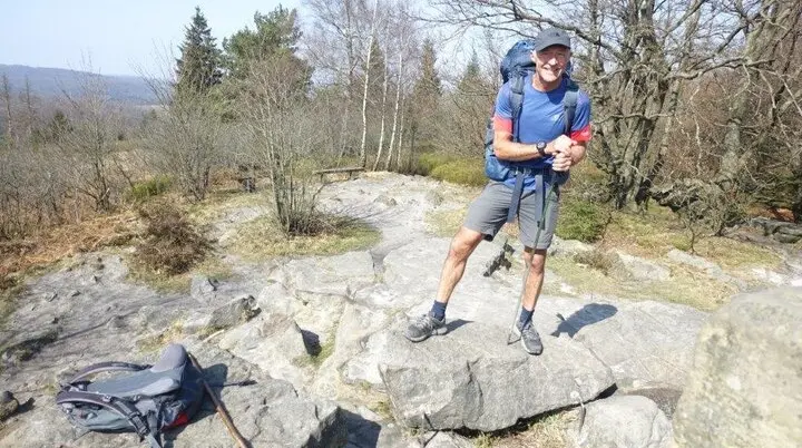 Es ist ein Wanderung auf dem Hermannsweg zu sehen auf einem Felsvorsprung | © DAV Münster