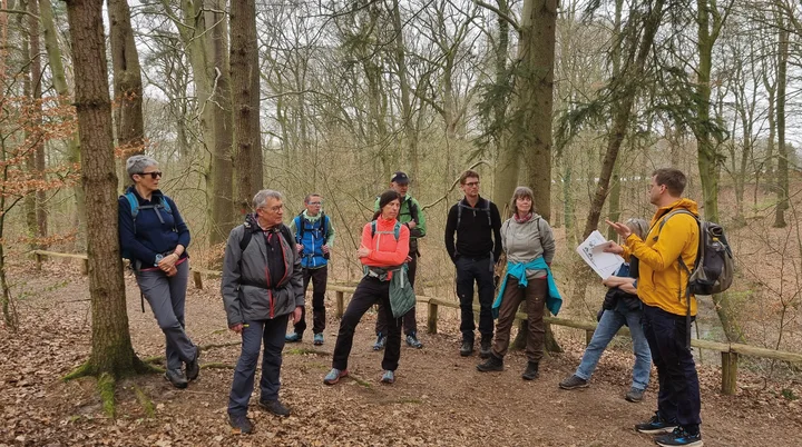 Naturwissenschaftlicher Vortrag von Johannes Aufgebauer während einer Wanderpause in einem Wald vor 8 Wanderern | © DAV Münster